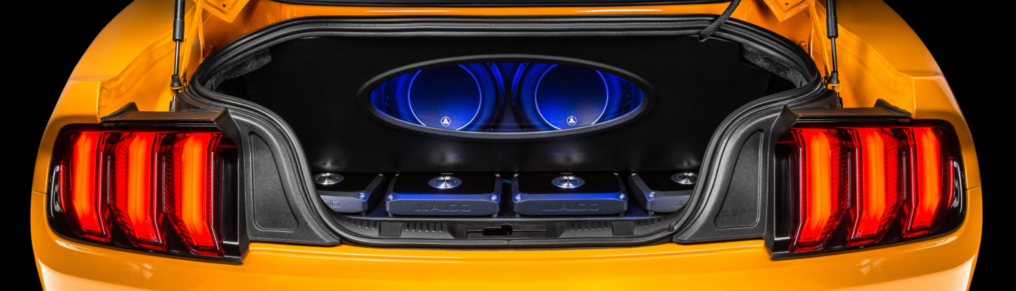 Yellow Mustang with a custom illuminated trunk audio system